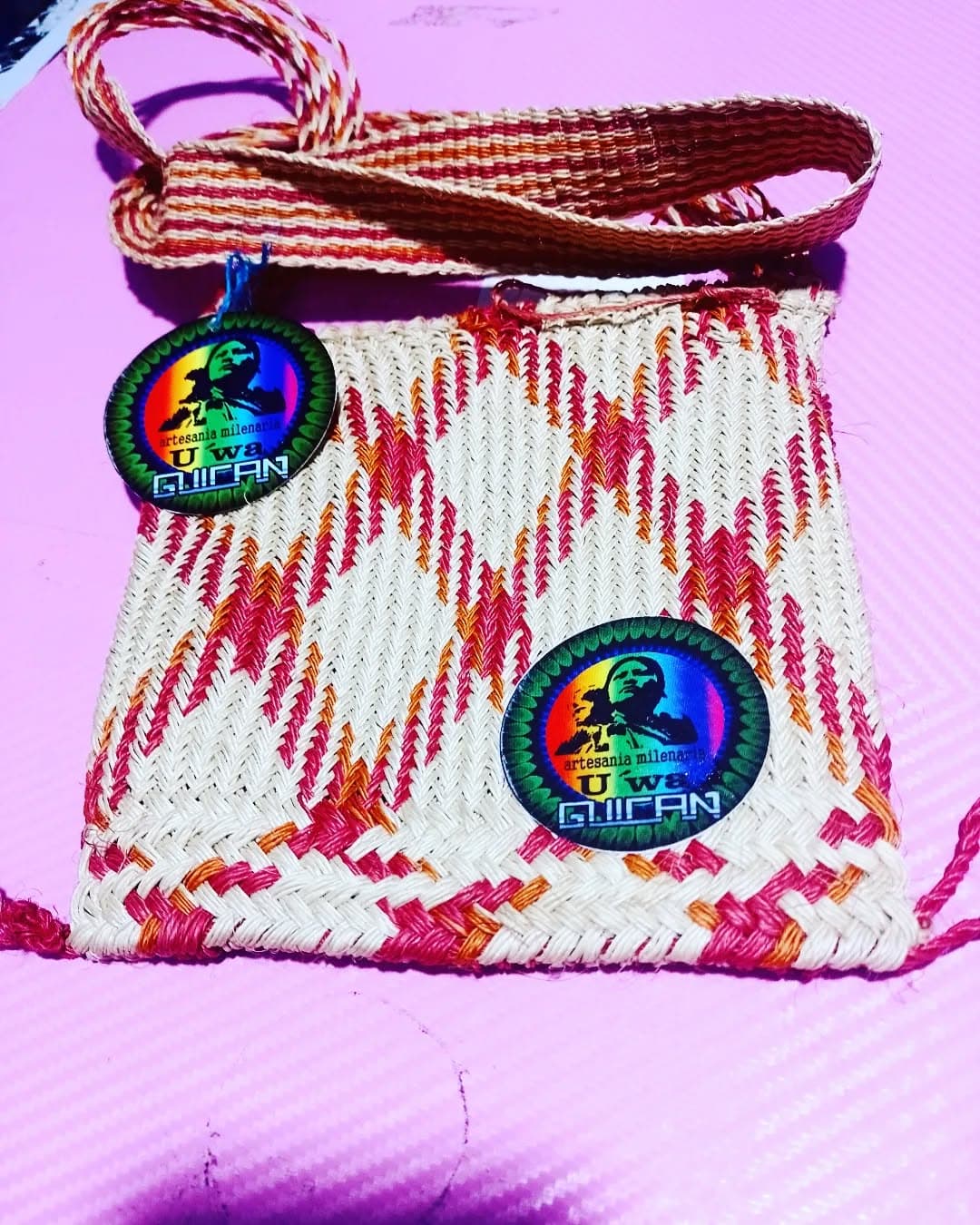Artesana U'wa tejiendo una mochila con patrones coloridos.