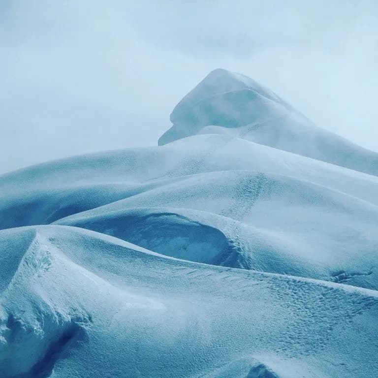 Vista de glaciar con formaciones de hielo azuladas y texturas superficiales.