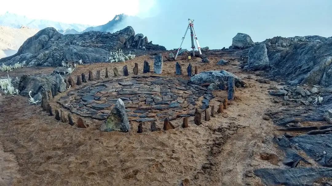 Estructura circular de piedra en medio de un paisaje montañoso.